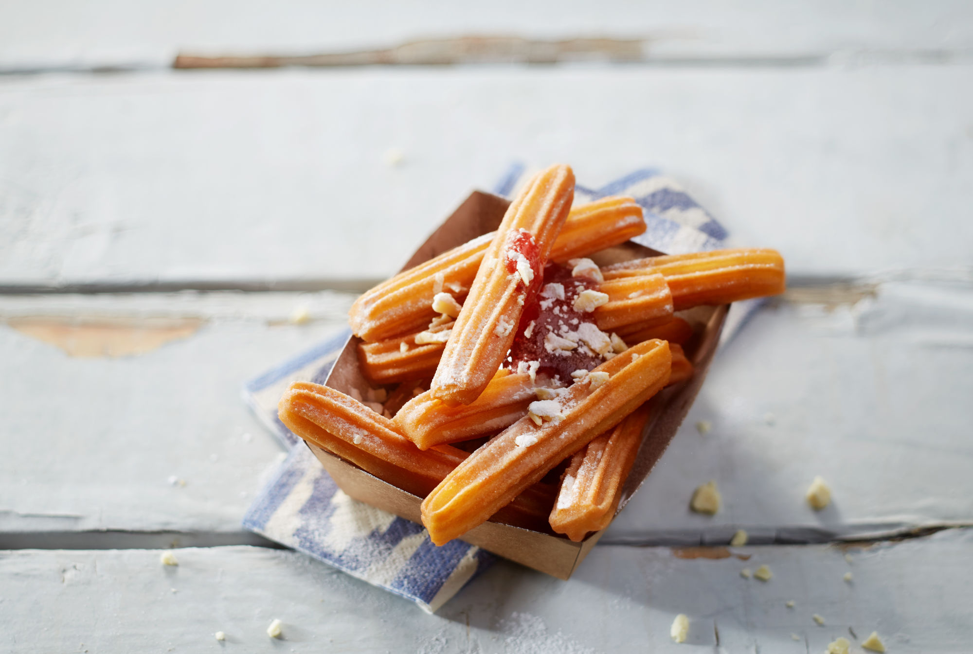 Churros with strawberry sauce and white chocolate shreds